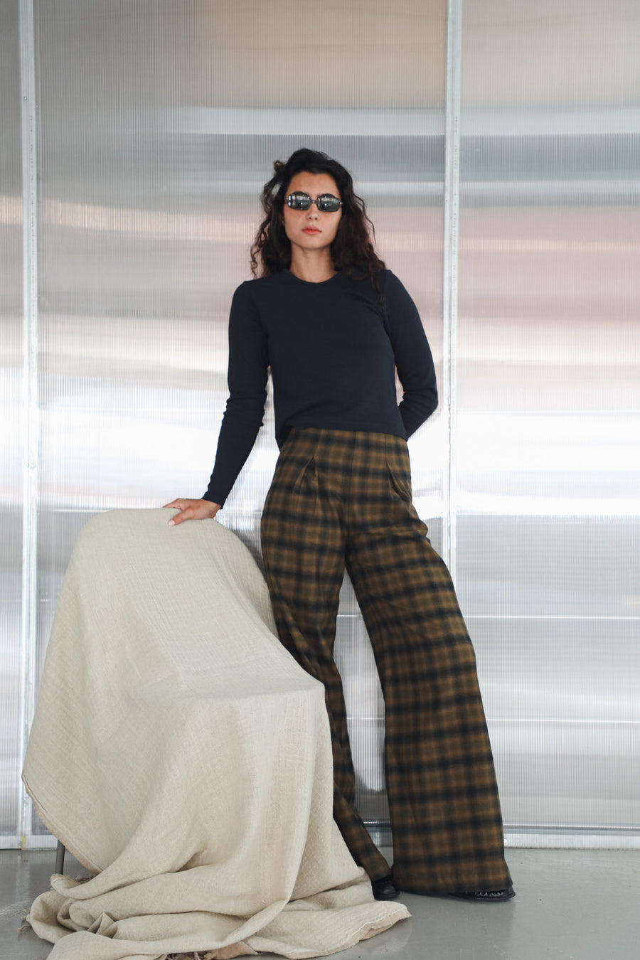 Full-length view of the Square Detail Pants Grey, high-waisted wide-leg pleated cotton trousers in grey and brown check, with the navy Long V-Neck T-Shirt in heavy organic cotton.
